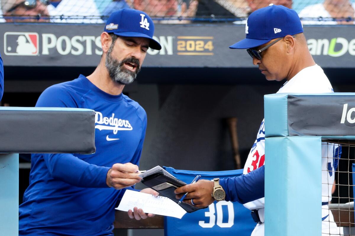 Dodgers pitching coach Mark Prior talks with manager Dave Roberts during Game 2 of the NLCS on Monday.