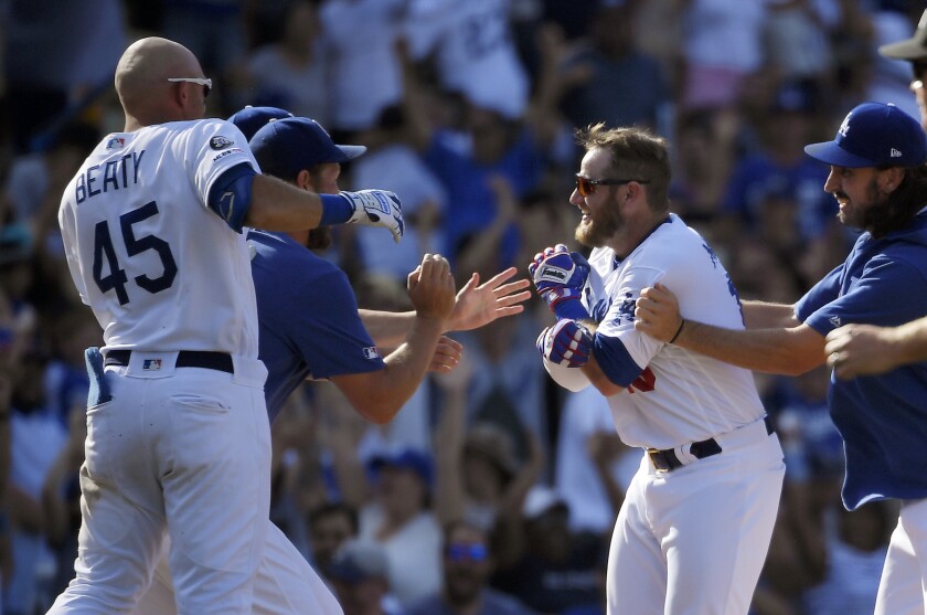 Max Muncy celebrates with his Dodgers teammates after hitting a walk-off double in an 11-10 victory over the Padres.