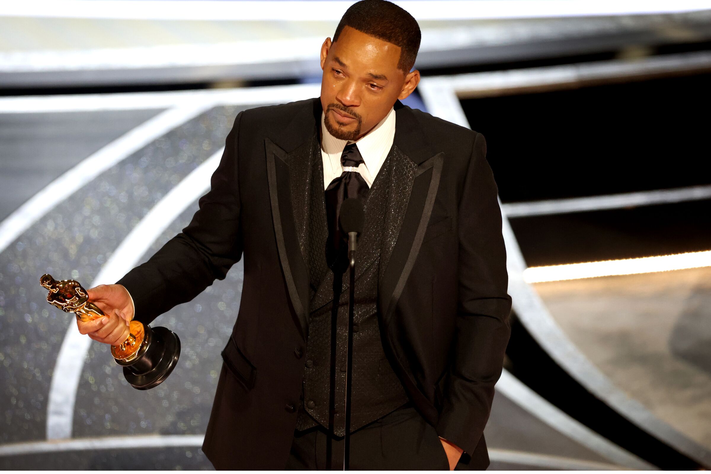  A man holds an Oscar and speaks at the Academy Awards ceremony.