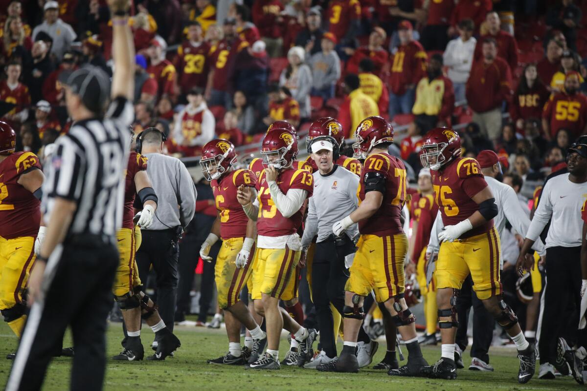 USC coach Lincoln Riley talks with his players on the sideline.