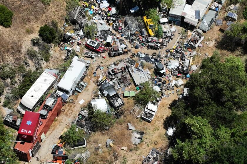 Sunland, CA - June 15: An aerial view of a 9-acre Sunland property owned by Mary Ferrera, 80, of La Crescenta, and occupied by her son David, 50, which has been the subject of years of complaints by neighbors. The owner was sentenced to jail time earlier this year for failure to clean it up. Photo taken in Sunland Saturday, June 15, 2024. Elena Malone and her husband, Josh Ryan, who are school teachers, bought their dream house in a horsey/moutainous area of Sunland. Their neighbor is a hoarder/mentally ill/drug addict who has made life very difficult for a street in Sunland and particularly one family. Next door was a 9 acre property owned by a retired school teacher and occupied by her troubled son, David Ferrera. At first he seemed friendly, but pretty soon his life fell apart and he and his equally troubled girlfriend were living in a car outside Malone's front gate. The property has no electricity or running water. There were stolen cars blocking the street, used condoms, trash bags of marijuana, anal plugs, human waste. The property itself is strewn with stolen cars (LAPD estimates 100 stolen vehicles on property) and unpassable to authorities. At one point Malone needed to pick her husband up from chemotherapy and couldn't get out of her gate. Her children cannot play outside. A judge earlier this year sentenced the elderly mother to jail - she was out in 11 hours - but said he couldn't do anything else and suggested Malone confront Karen Bass. The fire department had cleaned up the street somewhat, but the property itself is still a mess and a fire harzard (There have been several wildfires in this area.) (Allen J. Schaben / Los Angeles Times)