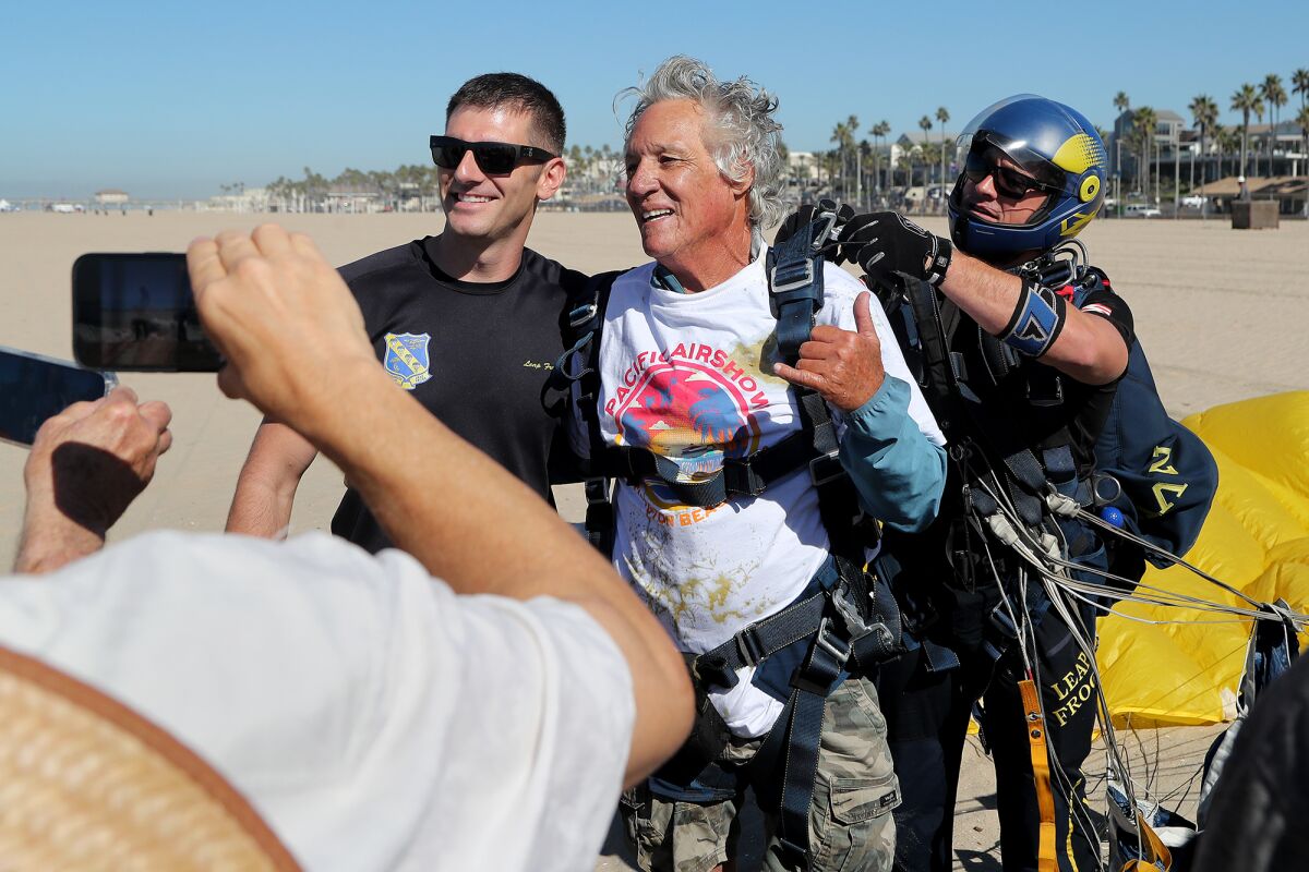 Don Ramsey, center, smiles for photos after tandem jumping out of a plane with the U.S. Navy Leap Frogs.