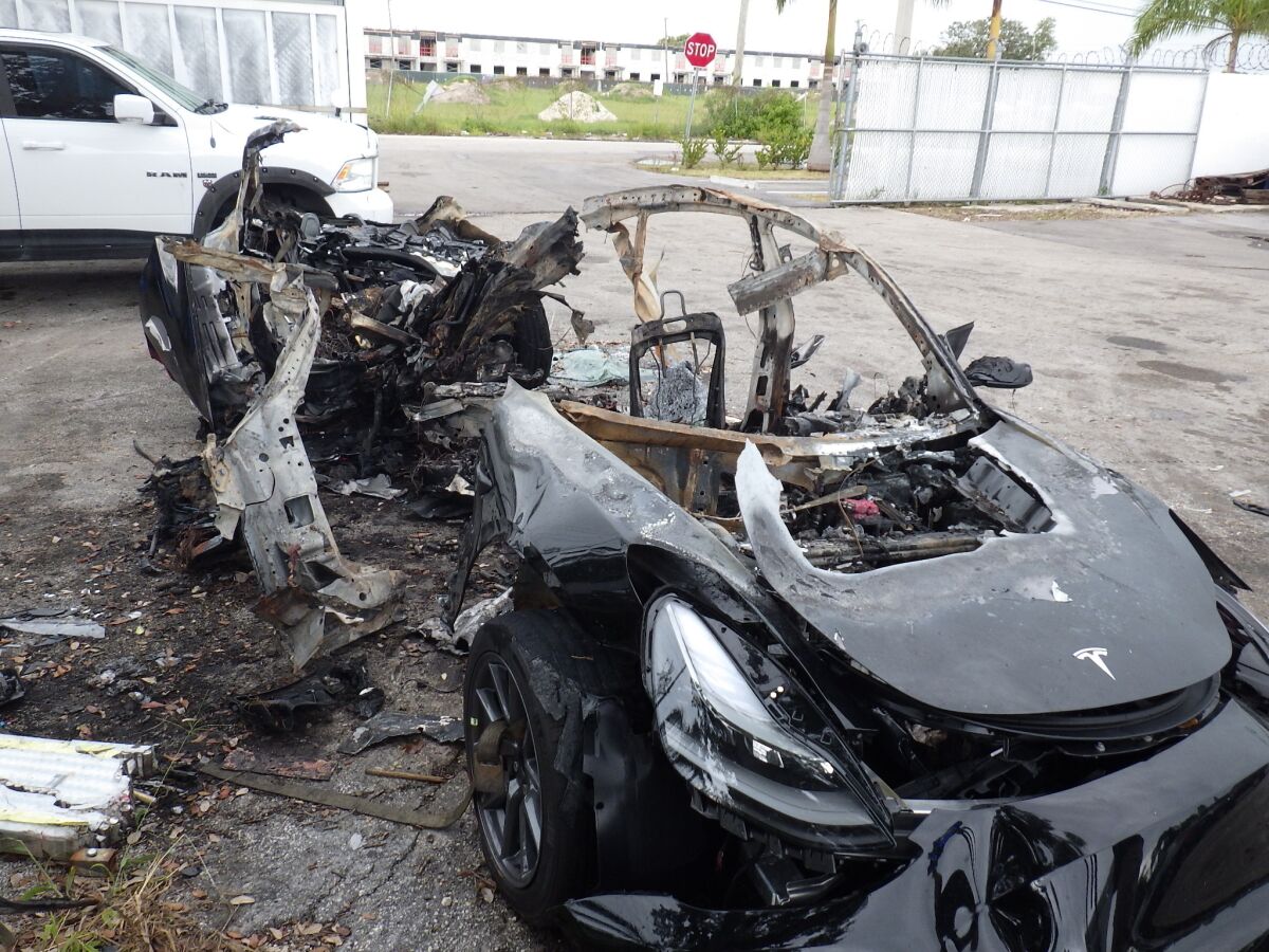 This image provided by the National Transportation Safety Board shows damage to a 2021 Tesla Model 3 Long Range Dual Motor electric car following a crash in September, 2021, in Coral Gables, Fla. The Tesla driver who died with a passenger in a fiery September crash near Miami accelerated to 90 mph (145 kph) in the seconds before he lost control and smashed into trees, federal investigators said in a preliminary report released Wednesday, Nov. 10, 2021. (NTSB via AP)