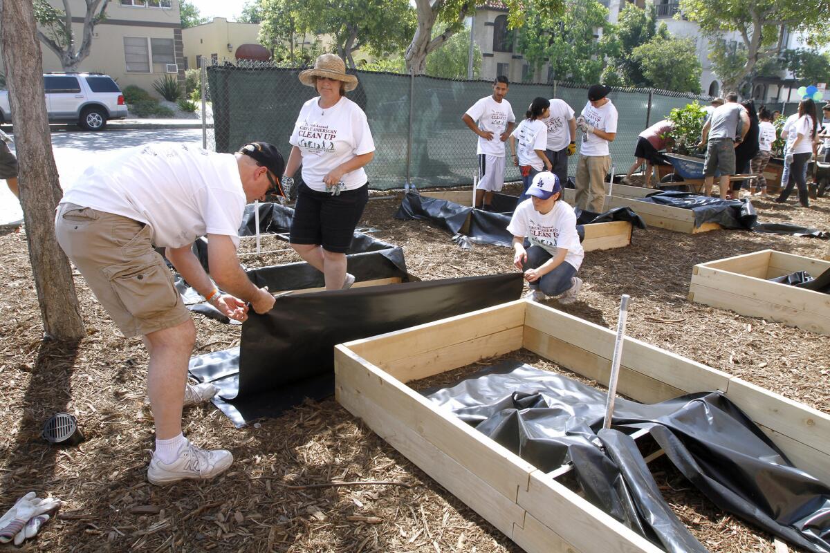 Volunteers like Wayne Herron, left, Teresa Mackey, center, and Tereza Aleksanian, right, helped build raised bed gardens at Daily High School in Glendale as part of the Great American Cleanup on Saturday, May 17, 2014. The gardens will be maintained by the Daily High School Environmental Futures Academy.