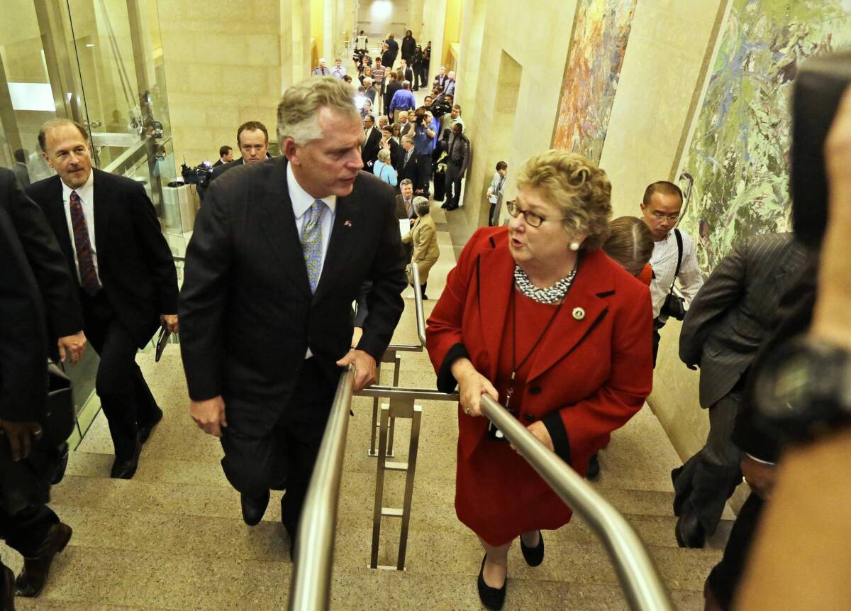 Virginia Gov.-elect Terry McAuliffe talks with the clerk of the state Senate, Susan Schaar, at the Capitol in Richmond after a news conference to announce his transition team.