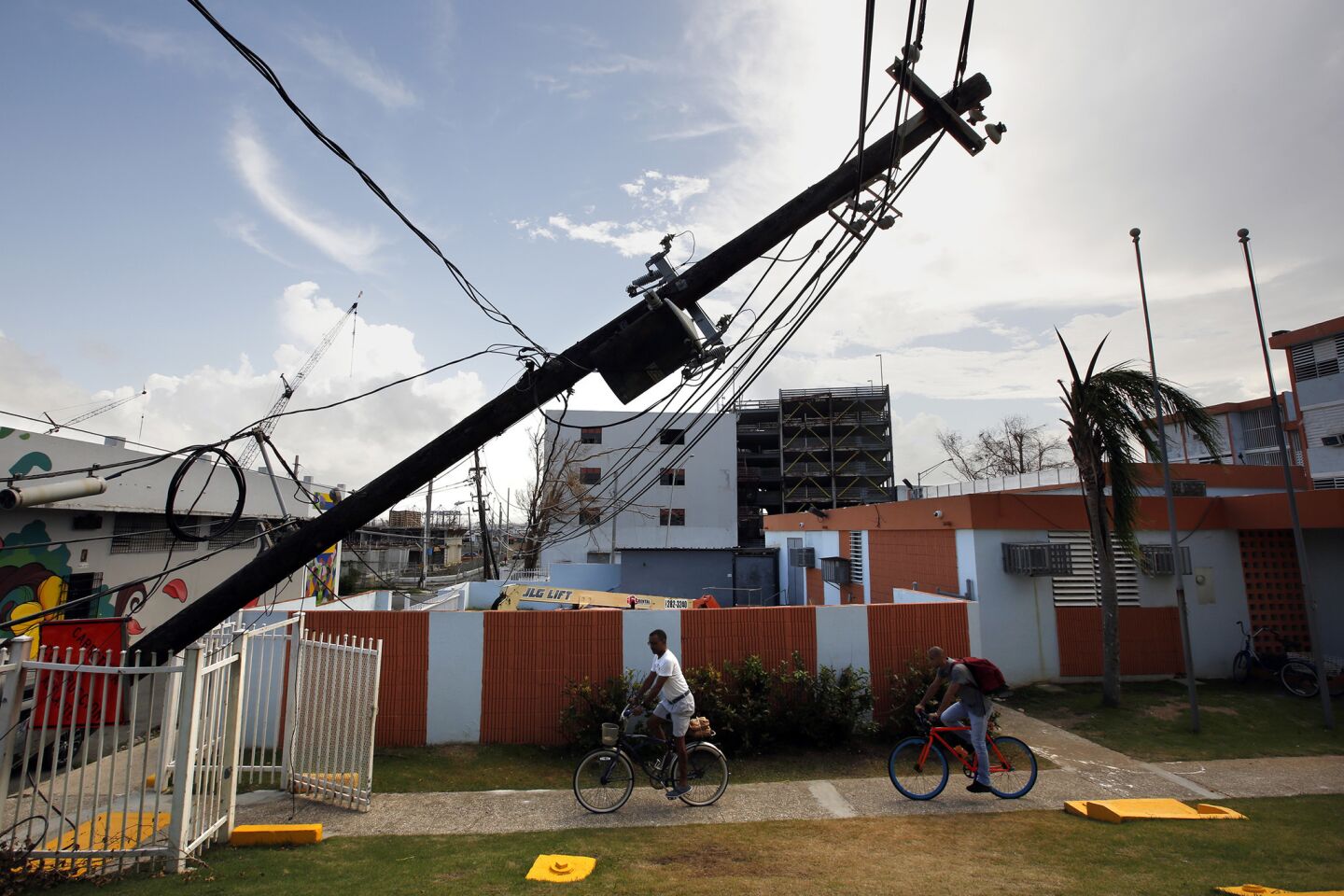 In downtown San Juan, electric lines lie in the road and poles block apartment complexes.