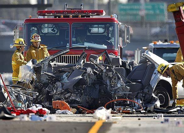 Los Angeles Fire Dept. firefighters view the wreckage of a Toyota Camry involved in a double-fatality accident on the eastbound side of 10 Freeway early Wednesday morning.