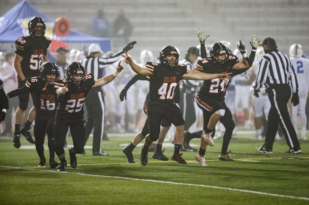 Huntington Beach defenders celebrate after a turnover against Fountain Valley during a Sunset League game on Friday.