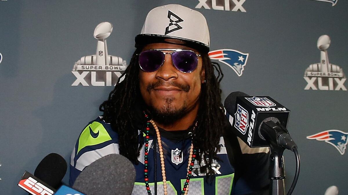 Seattle Seahawks running back Marshawn Lynch smiles while attending a Super Bowl XLIX news conference in Chandler, Ariz., on Jan. 28.