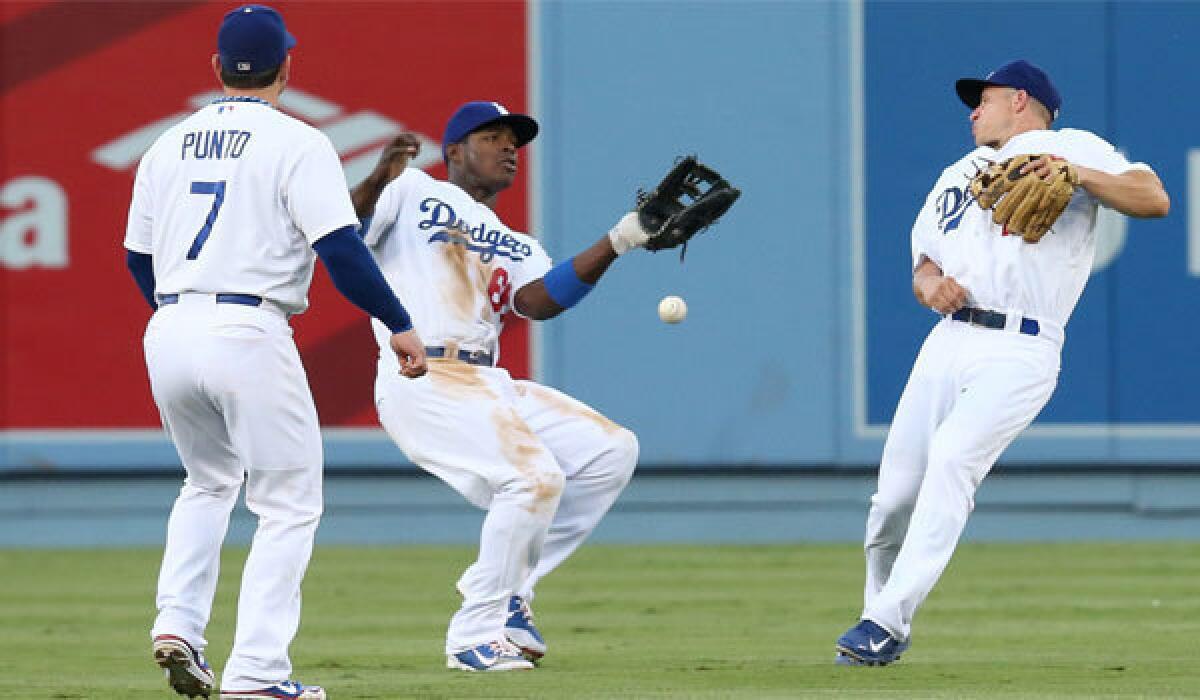 Dodgers center fielder Yasiel Puig drops a pop fly for an error between shortstop Nick Punto and second baseman Mark Ellis in the second inning against San Francisco on Saturday.