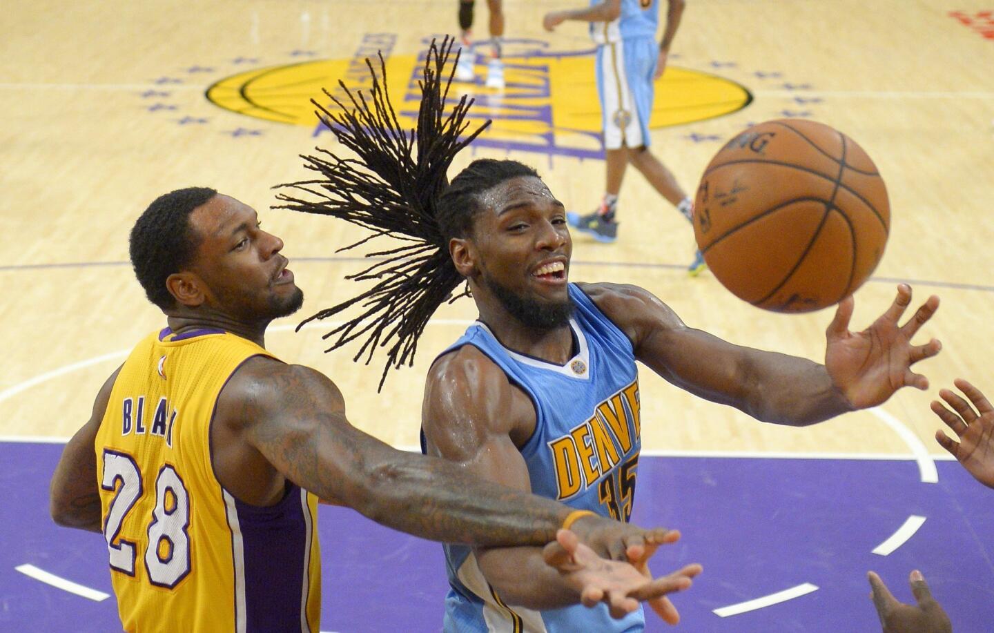 Los Angeles Lakers center Tarik Black, left, and Denver Nuggets forward Kenneth Faried reach for a loose ball during the second half of an NBA basketball game Tuesday, Nov. 3, 2015, in Los Angeles. The Nuggets won 120-109. (AP Photo/Mark J. Terrill)