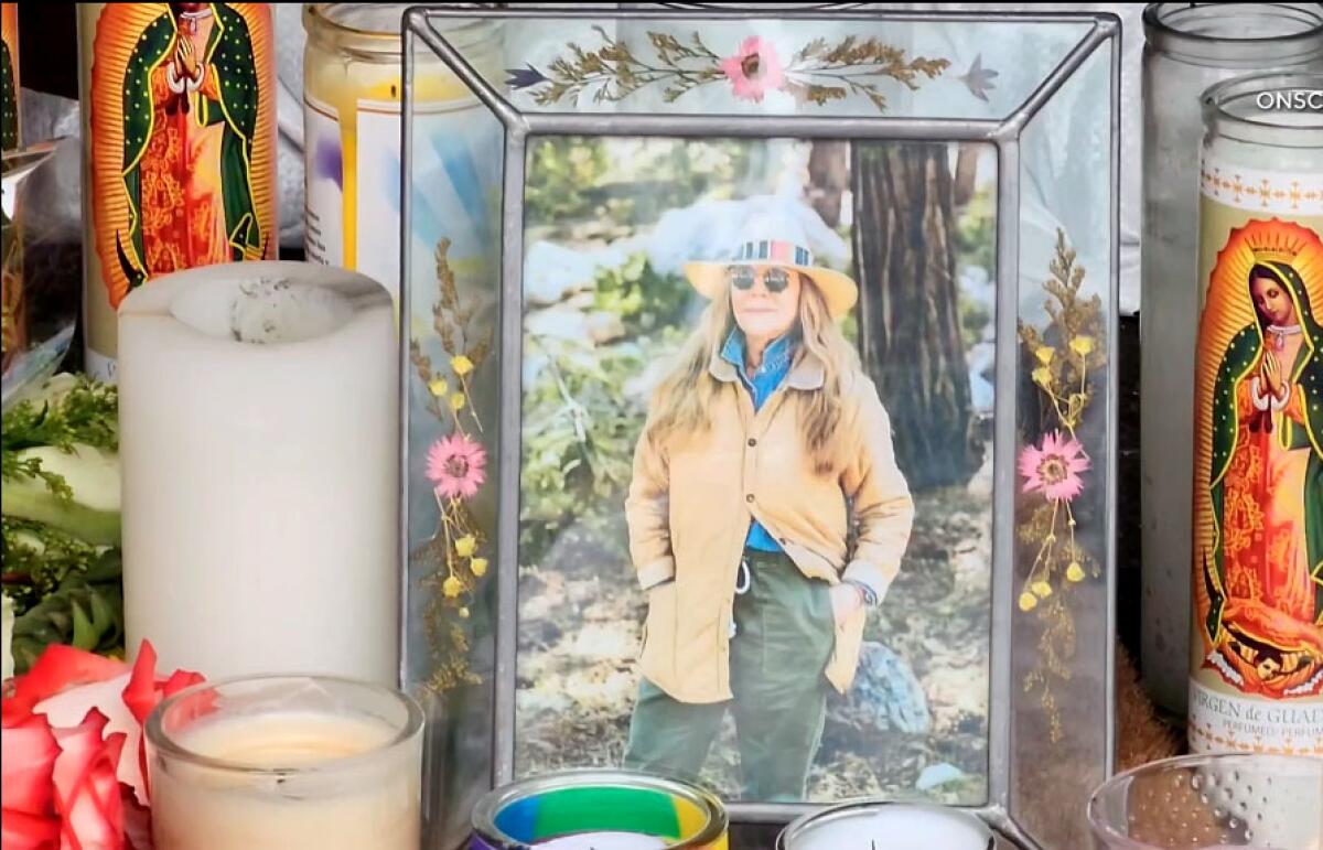 A framed photo of Laura Ann Carleton stands among candles outside her store in Cedar Glen where she was killed