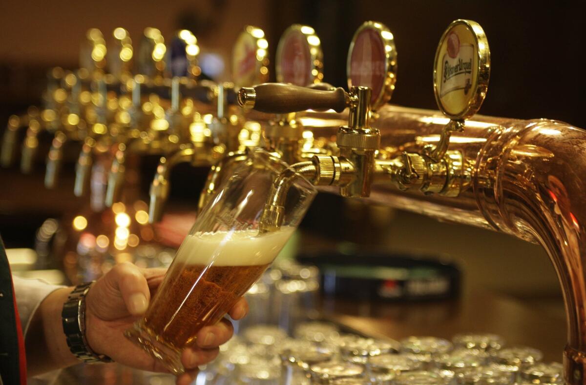 A bartender pours a glass of beer at a restaurant in the Pilsner Urquell factory in Pilsen, Czech Republic.