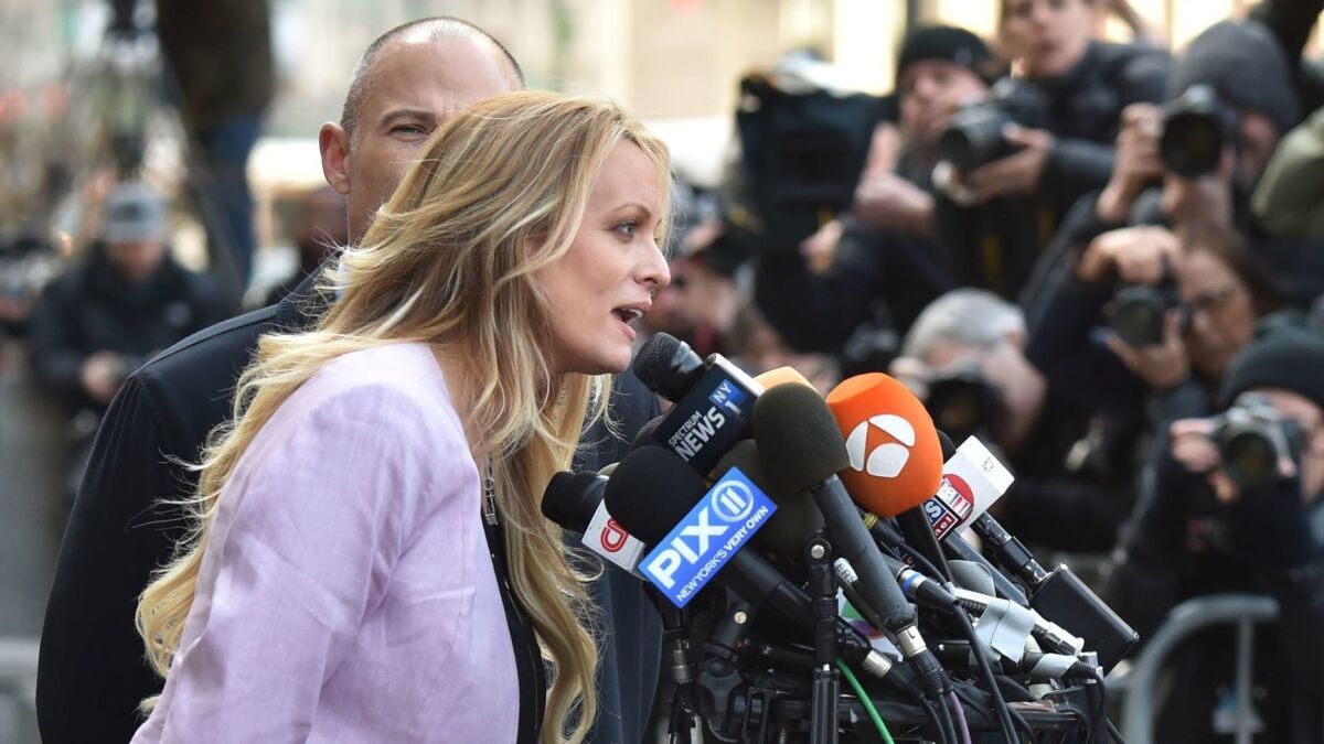 Stormy Daniels, whose real name is Stephanie Clifford, speaks outside court in New York with her lawyer, Michael Avenatti.