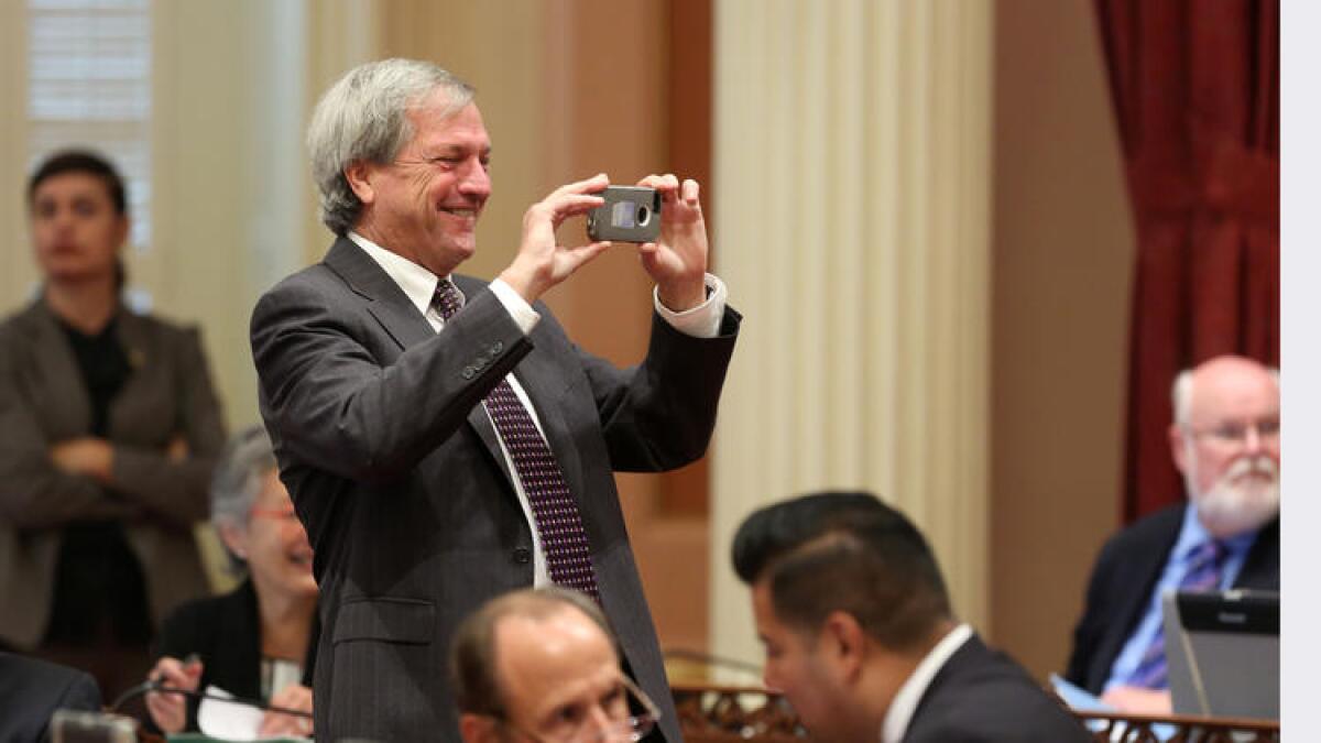 Then-state Sen. Mark DeSaulnier (D-Concord) takes a photo during the 2014 Senate session.