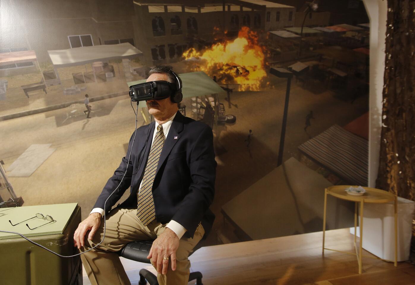 A guest views a war-torn street in Iraq through a virtual reality headset during a preview of “Bravemind: Using Virtual Reality to Combat PTSD,” a new exhibit at the Heroes Hall veterans museum at the OC Fair & Event Center in Costa Mesa. The breakthrough technology, created by USC's Institute for Creative Technologies, is used to treat post-traumatic stress disorder in military service members.