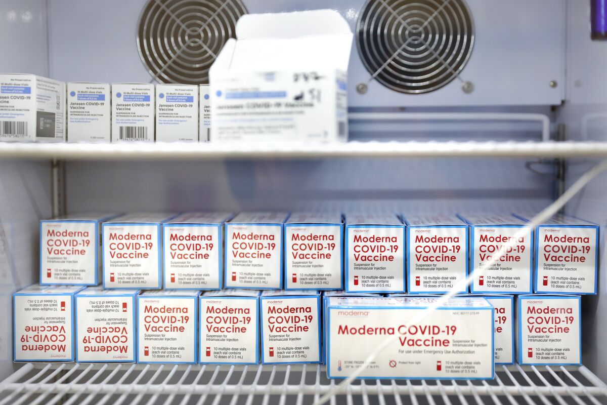 Moderna and Johnson & Johnson vaccines sit inside a refrigerator.