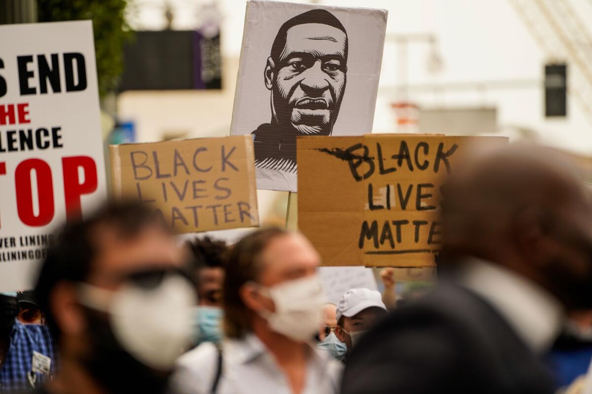 A sign with the likeness of George Floyd is seen at a protest outside L.A. City Hall.