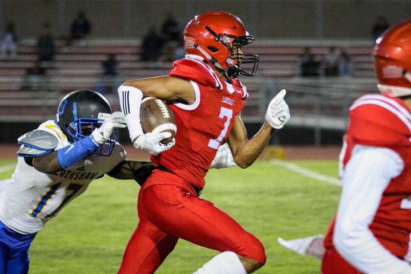 Lawndale's Makell Esteen tries to outrun the tackle attempt by a Crenshaw defensive back after making a catch during a game on Sept. 14, 2018.