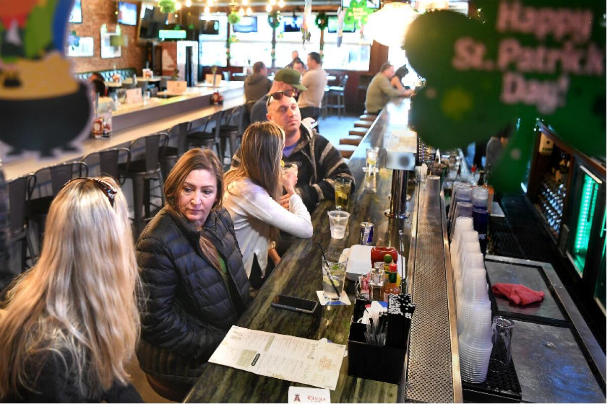 Kim Schoen, left, and Michelle Accardo spend time at Patrick Molloy’s Sports Pub in Hermosa Beach. California Gov. Gavin Newsom on Sunday issued an order for bars to close because of the spread of the coronavirus.
