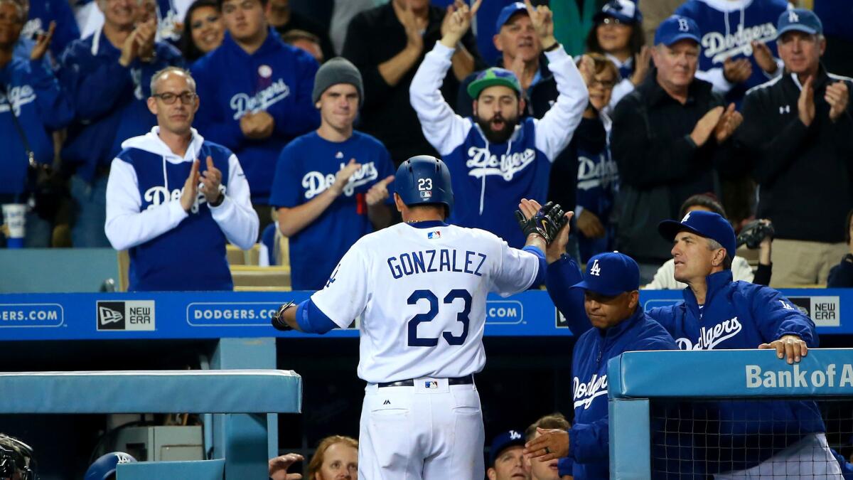 Adrian Gonzalez receives a standing ovation from Dodgers fans and high-fives from teammates and coaches after hitting a solo home run against the Diamondbacks in the fourth inning Wednesday.