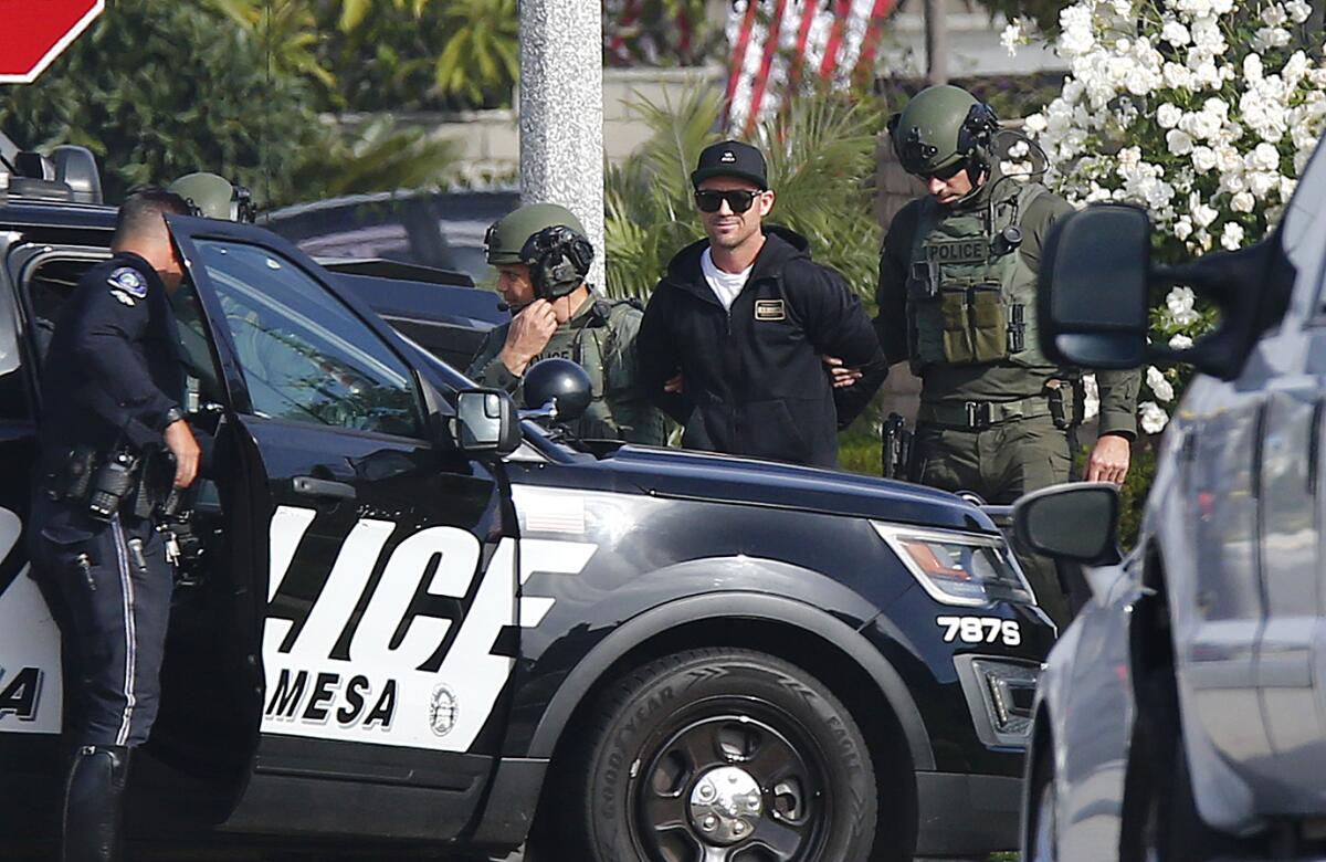 Tyler Nathan Thornton is taken into custody by Costa Mesa police officers after an hours-long standoff on Wednesday morning.