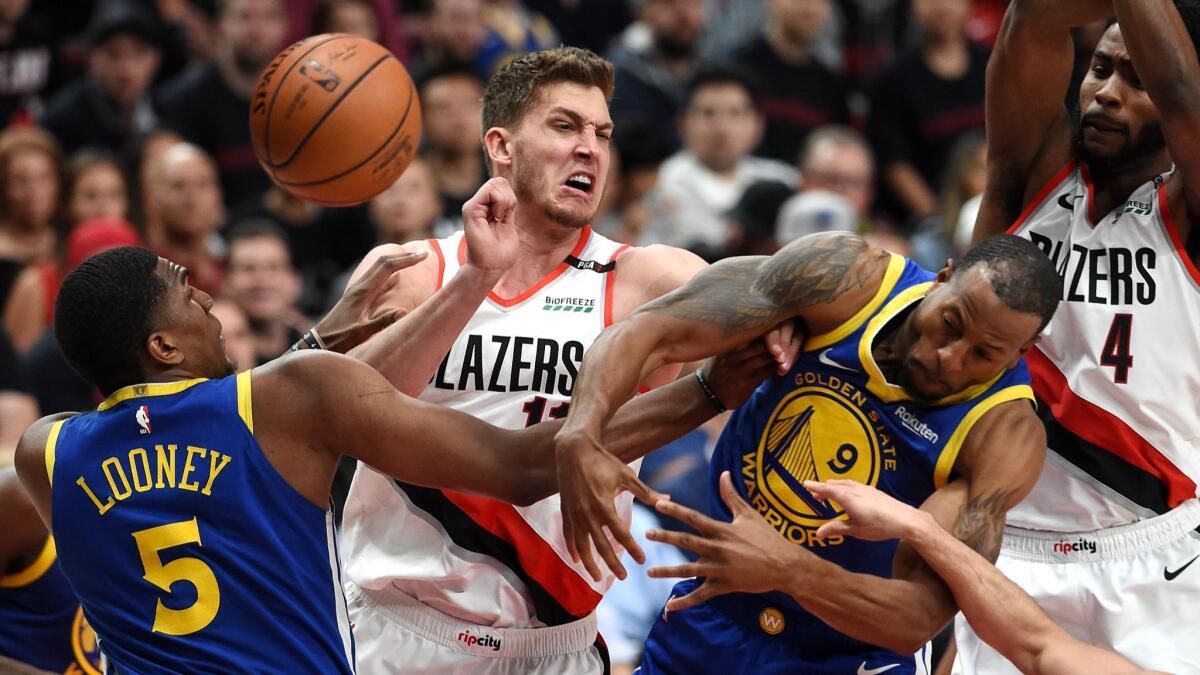 Portland's Meyers Leonard battles Kevon Looney and Andre Iguodala for a loose ball during Game 3 of the Western Conference finals.