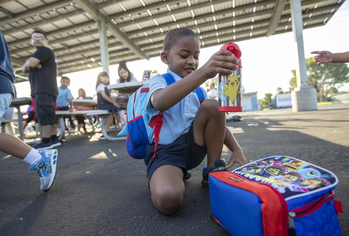 Legend Ellison, 5, checks out lunch on opening day Tuesday of the new International School for Science and Culture charter school in Costa Mesa. The school is at the Newport-Mesa Unified School District's Harper Assessment Center site.