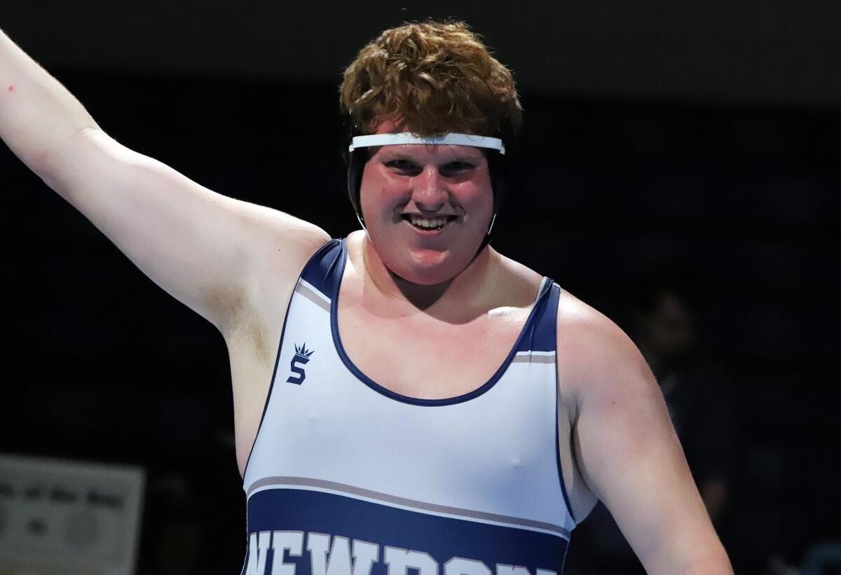 Newport Harbor's Everett Heninger raises his arm in victory after winning the decisive heavyweight match.