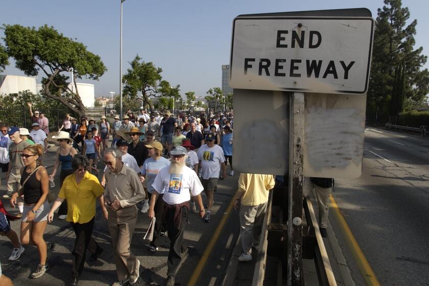 06/15/2003: Pedestrians walk on the 110 Pasadena Freeway as part of the Arroyo Fest, Sunday, June 15, 2003, in Pasadena, Calif. The freeway, the first of its kind in the U.S. which was opened in 1944, was shut down for several hours so that residents could take the time to appreciate the historic Arroyo Seco canyon. KEYWORDS: CALIFORNIA. HISTORY. STREETS AND ROADS (AP Photo/Joe Cavaretta)