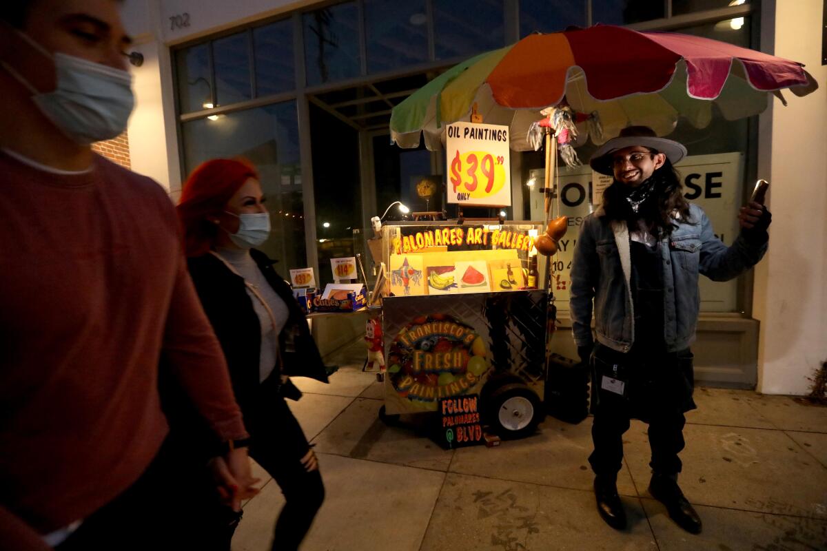 Artist Francisco Palomares stands in front of his converted fruit cart.