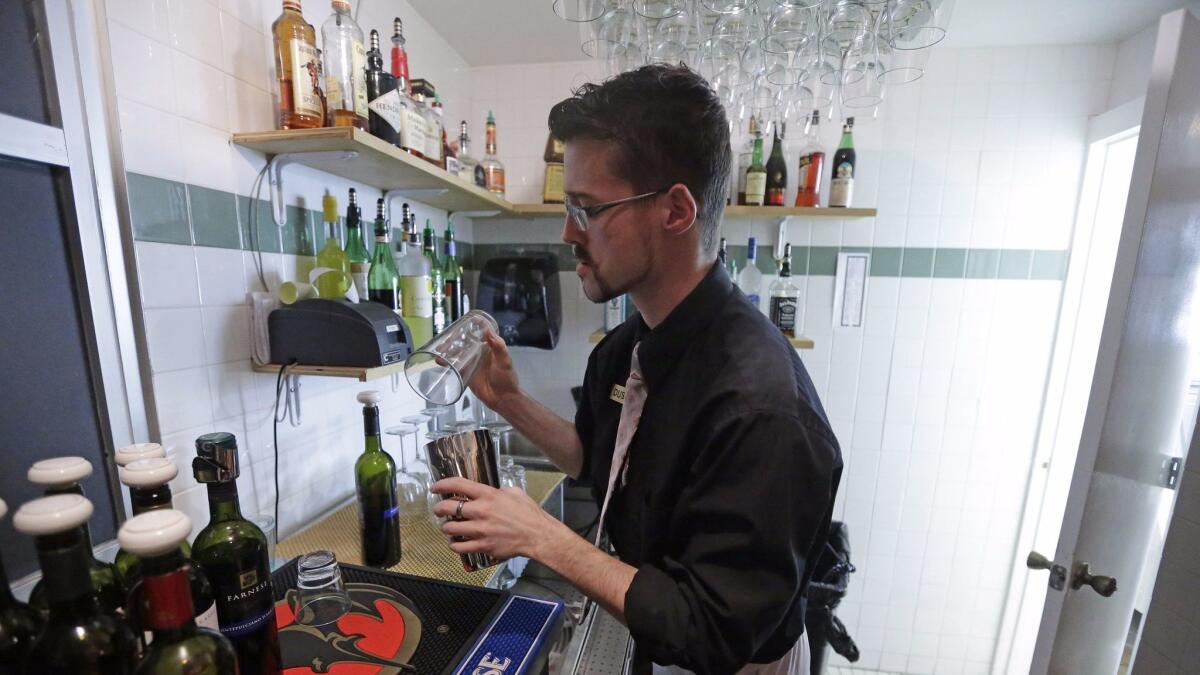 Dustin Humes fixes a drink out of the view of patrons at Vivace Restaurant in Salt Lake City, in keeping with one of Utah's strict laws on alcohol.
