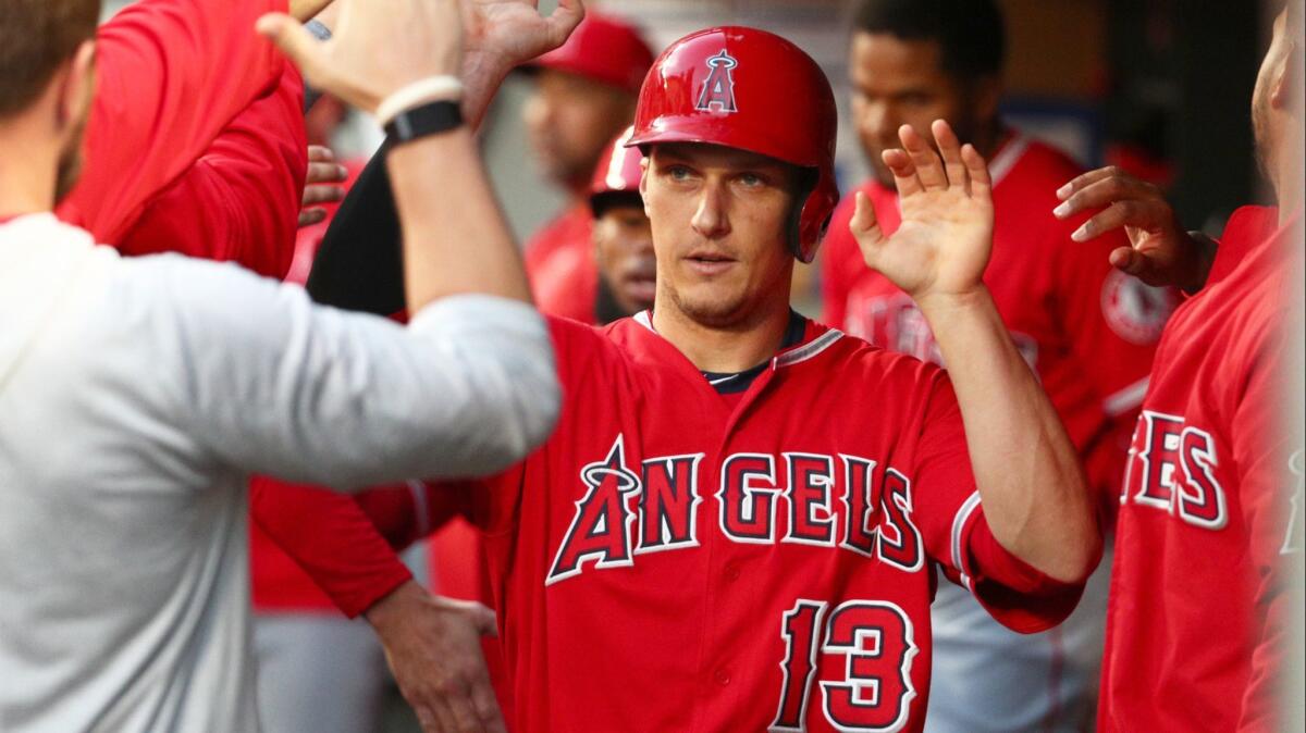 Dustin Garneau celebrates in the dugout after scoring a run against the Seattle Mariners on May 30. Garneau once hosted Tyler Skaggs on a recruiting visit to Cal State Fullerton.