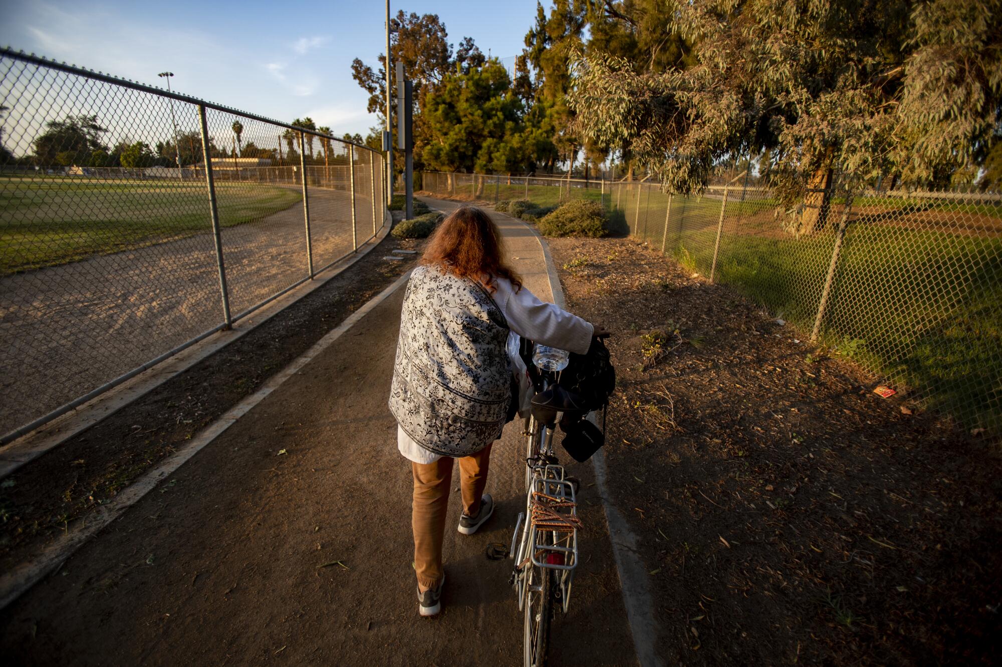 Nancy Wood walks with her bicycle back to her tent