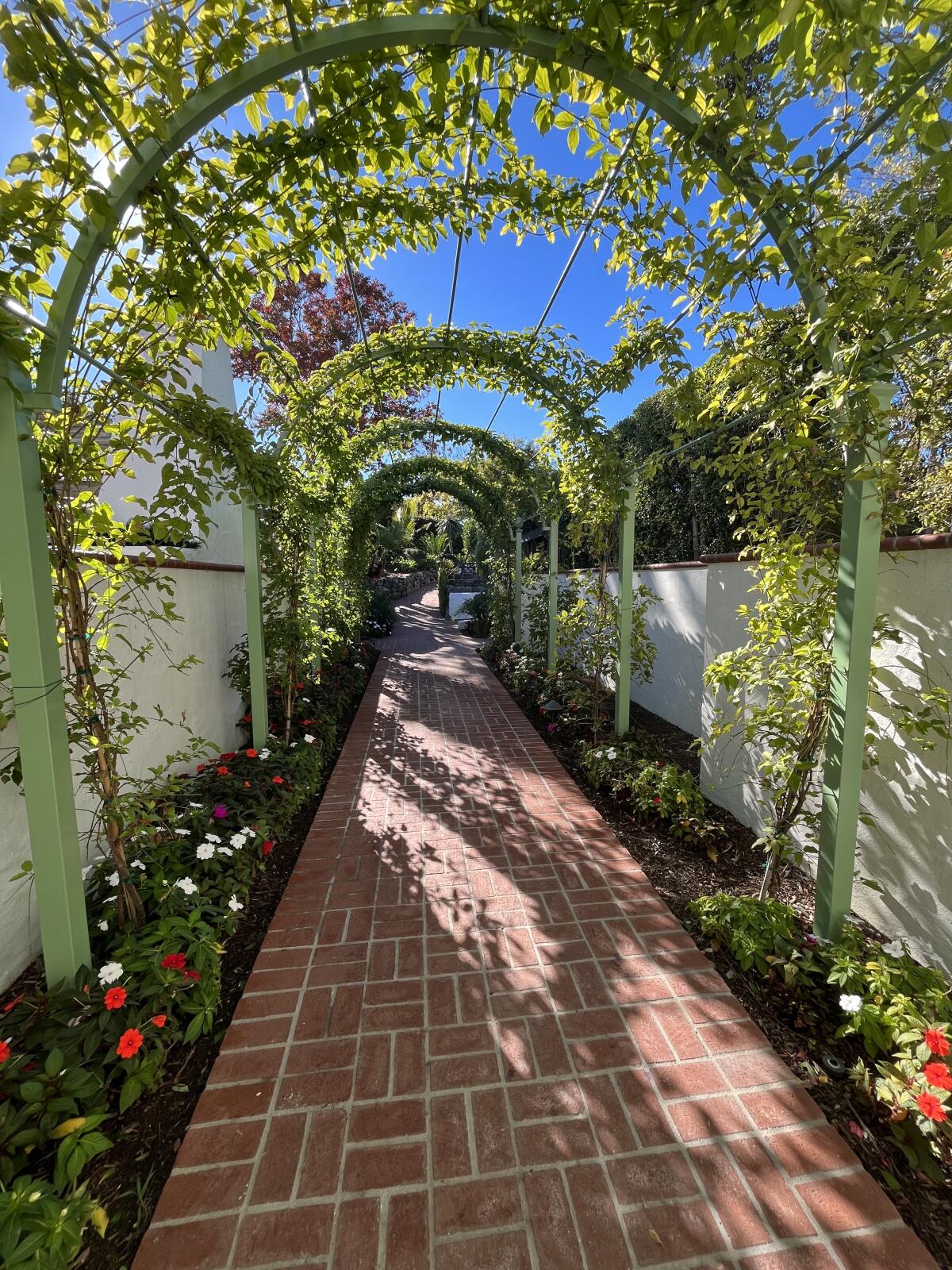 The Inn's landscaping includes a green archway leading the guest rooms.