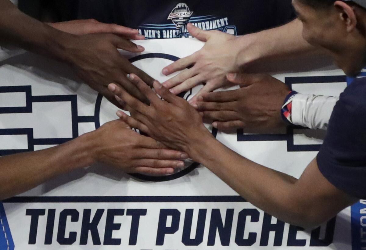 Villanova players stick a logo of their team on a bracket board after defeating Seton Hall in 2019.