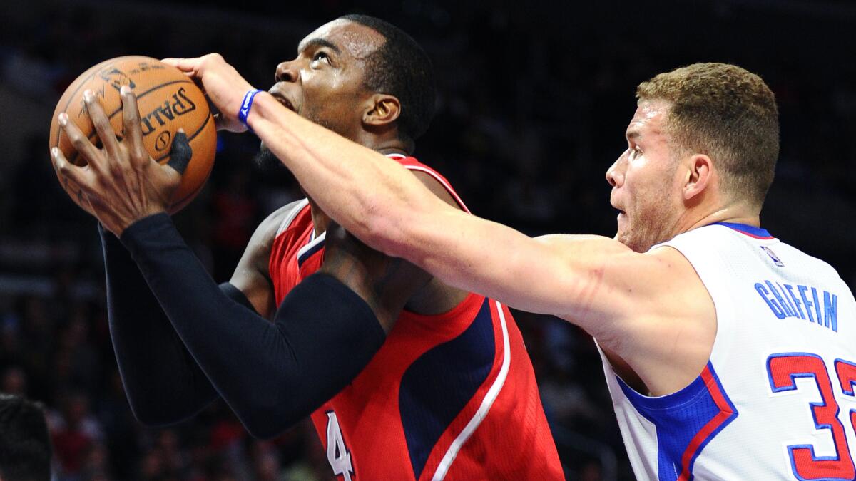 Clippers forward Blake Griffin tries to block a shot by Atlanta Hawks forward Paul Millsap during the Clippers' 107-98 loss at Staples Center on Monday.