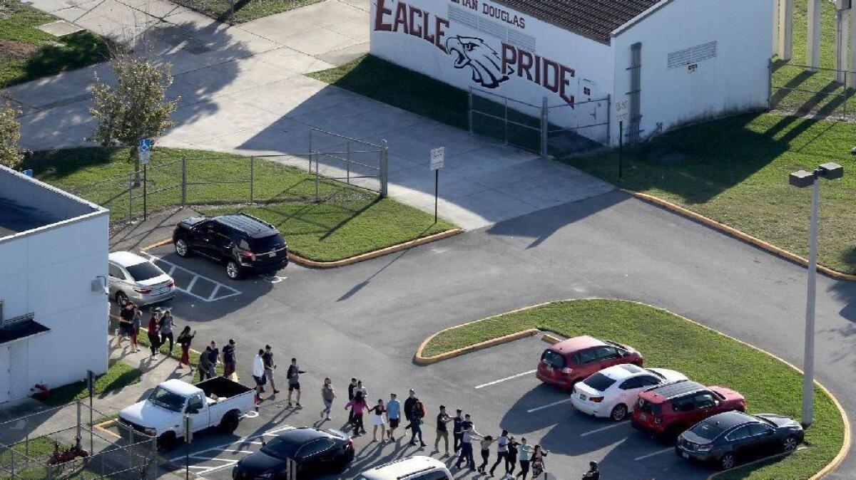 Students are evacuated in February from Marjory Stoneman Douglas High School in Parkland, Fla., after a shooter opened fire; 17 people died.