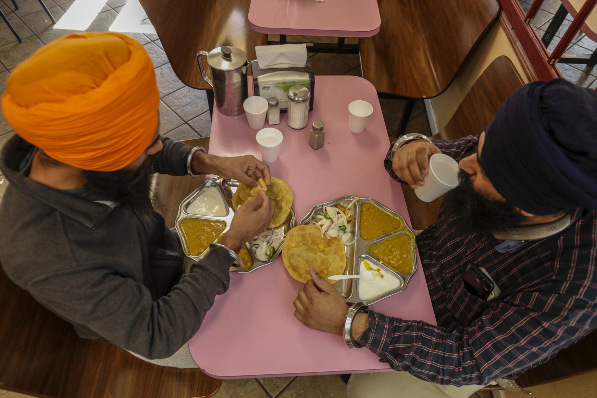 Two Sikh truckers have dinner.