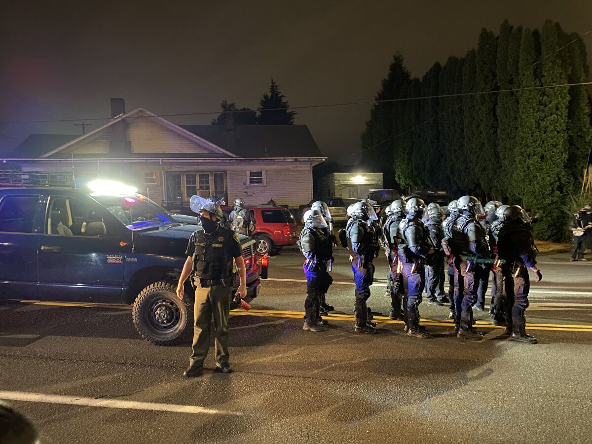 Multnomah County sheriff’s deputies in Portland line up to clear protesters off a street.