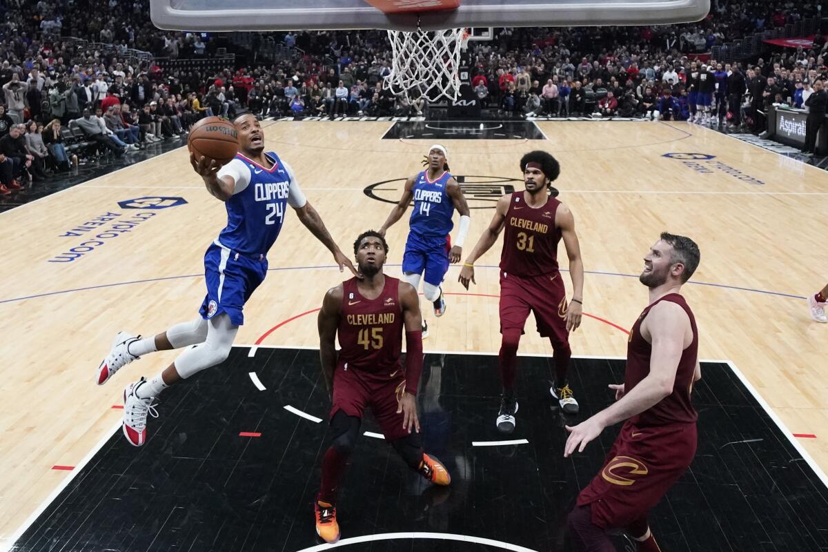 The Clippers' Norman Powell, left, puts up a shot during the second half of the team's win Monday.