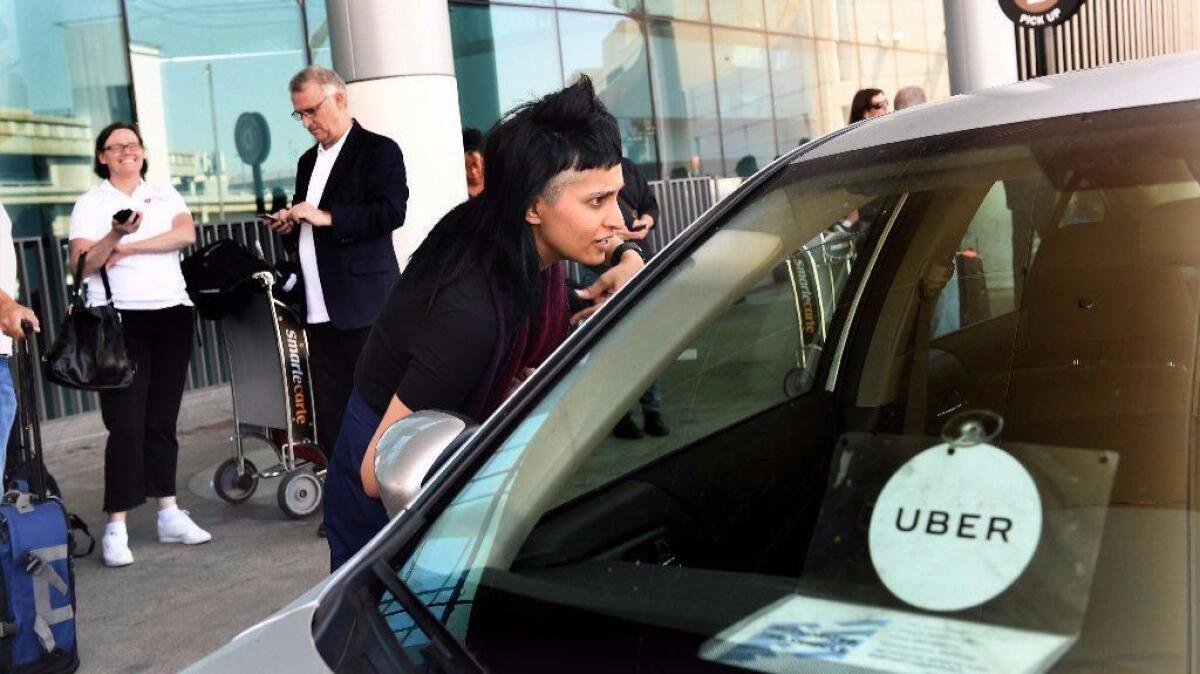 A customer talks to an Uber driver at the Tom Bradley Terminal at Los Angeles International Airport. Uber is the most popular ground transportation among business travelers.