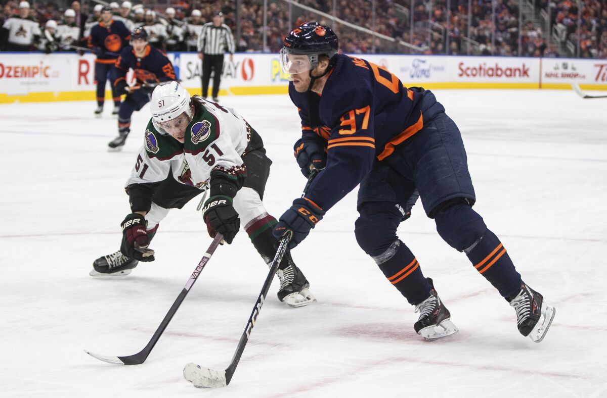 Arizona Coyotes' Troy Stecher (51) tries to stop Edmonton Oilers' Connor McDavid (97) during the second period of an NHL hockey game in Edmonton, Alberta, on Wednesday, Dec. 7, 2022. (Jason Franson/The Canadian Press via AP)