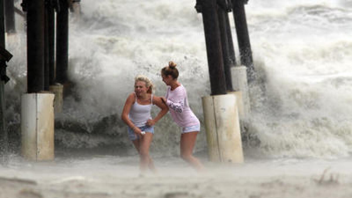 Kaleigh Black, 14, left, and Amber Olsen, 12, run for cover as a squall with rain and wind from the remnants of Hurricane Matthew pelt them Friday in Cocoa Beach, Fla.