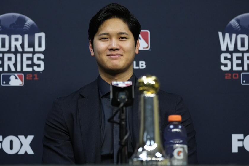 Shohei Ohtani wins the Commissioner's Historic Achievement Award from Rob Manfred before Game 1 in baseball's World Series between the Houston Astros and the Atlanta Braves Tuesday, Oct. 26, 2021, in Houston. (AP Photo/Ashley Landis)