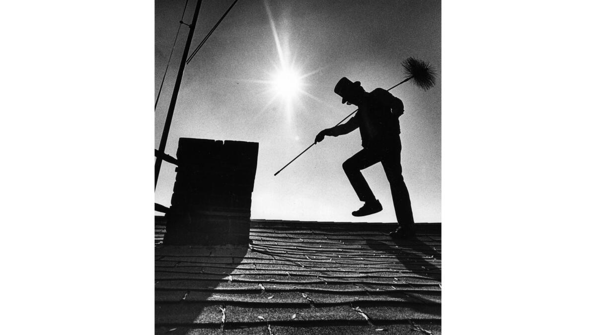Aug. 11, 1987: Chimney sweep Brad Kepford making his way to a chimney on an uptown Whittier rooftop.