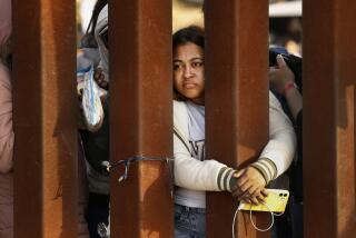 U.S. border, United States-May 12, 2023-Migrants ask for help to get their phones charged. Migrants rrely on their mobile phones for directions, communication with family and friends, and sometimes social media. Title 42 has expired, but migrants hoping to cross into the United States from Tijuana, Mexico remain on the border on May 12, 2023. Some migrants have been waiting a week in an area south of the second border wall in anticipation of a change in immigration policy, Title 42, which may allow them to apply for asylum. U.S. border patrol agents give out one bottle of water and one granola bar to each person. There are approximately 500 people in this one camp. (Carolyn Cole / Los Angeles Times)