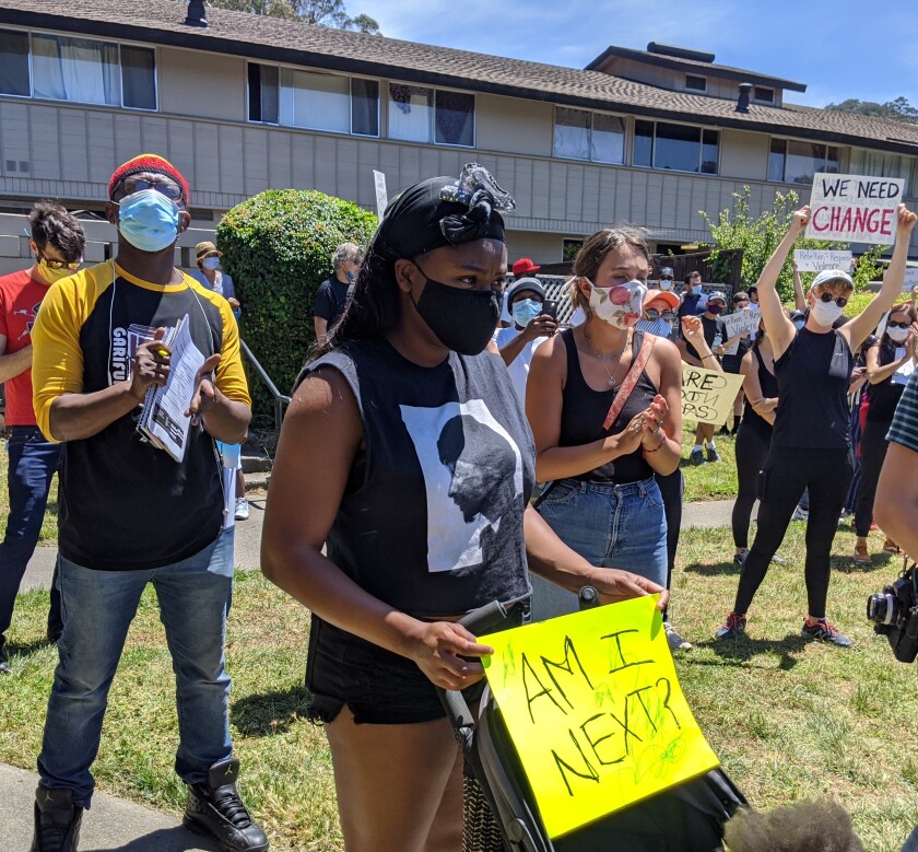 Chenetta Richardson holds a "Am I Next?" sign at a protest against police violence. 