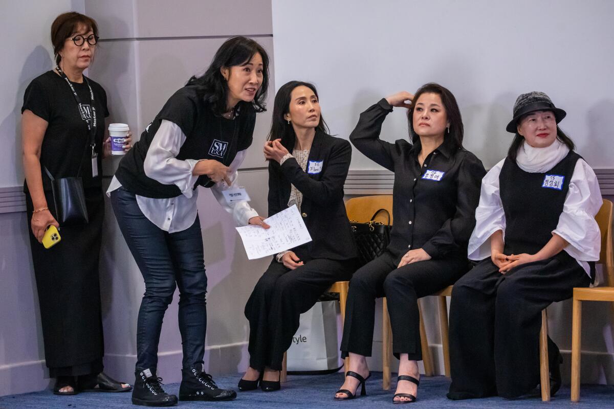 Flora Yi, seated left, Kelly Kang and Seong Hee Jeong wait their turns during the auditions.