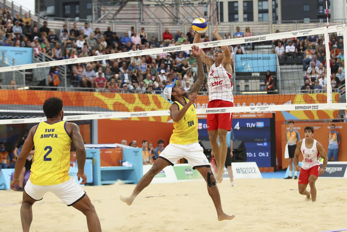England's Joaquin Bello, second right, and Tuvalu's Saaga Malosa, second left, and Ampex Isaac, left, in action during the Men's Doubles match between England and Tuvalu at Smithfield on day two of the 2022 Commonwealth Games in Birmingham, England, Saturday July 30, 2022. (Isaac Parkin/PA via AP)